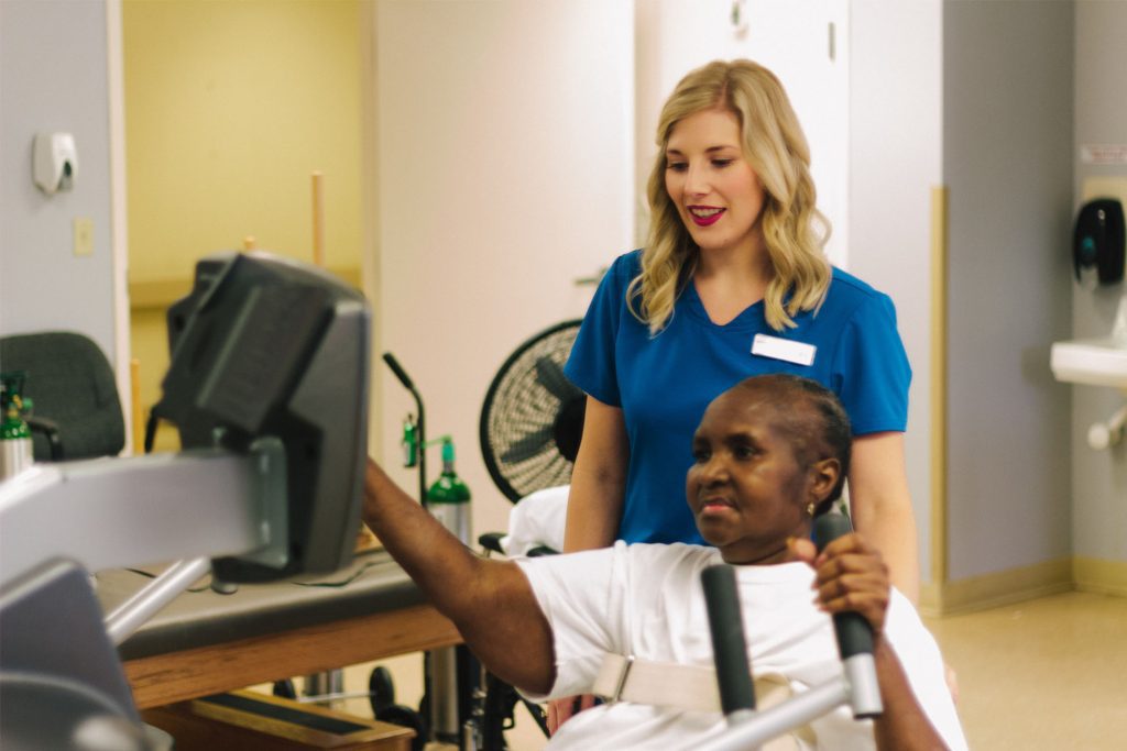 A woman uses physical therapy equipment at a short term care facility