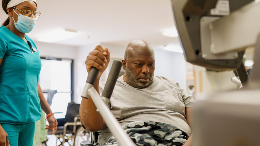 A man in short term rehab does physical therapy with the help of a nurse