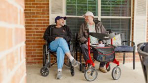 Two men laugh together at a skilled nursing facility